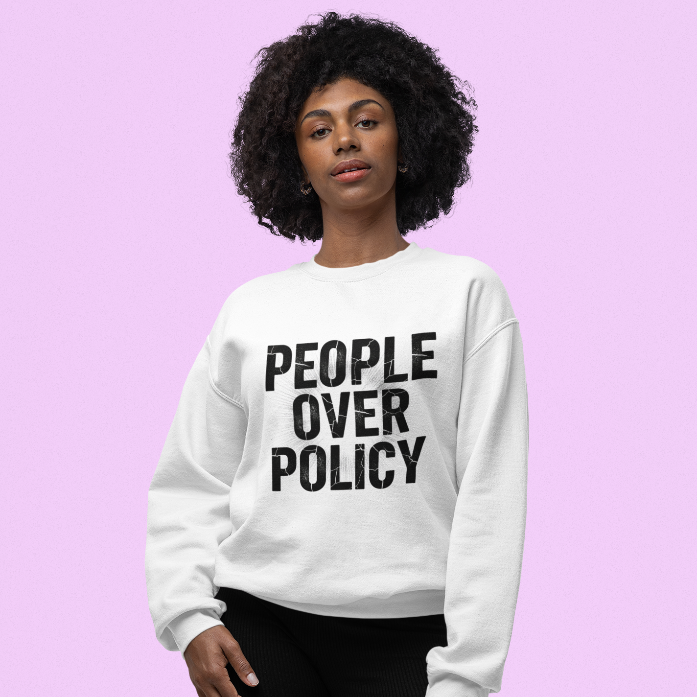 Person wearing a white sweatshirt with 'People Over Policy' text on a pink background