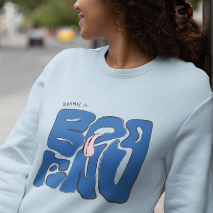 Person wearing a light blue sweatshirt with a graphic design, standing outdoors.