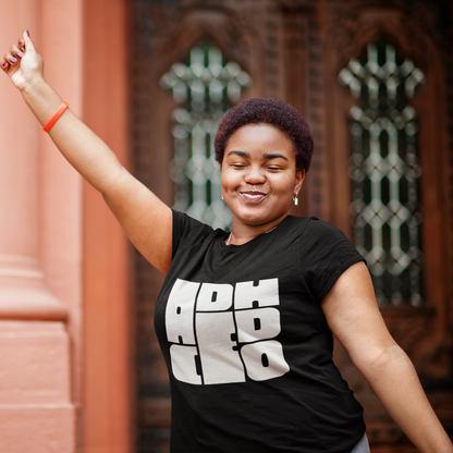 Woman wearing a black t-shirt with white text, standing outdoors with a blurred background