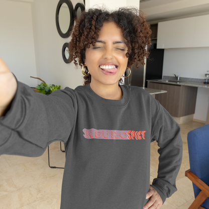 Woman wearing a gray sweatshirt with text, standing in a modern kitchen.